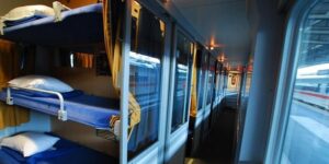 Sovvagn med bäddar och avskilda kupéer längs en smal mittgång